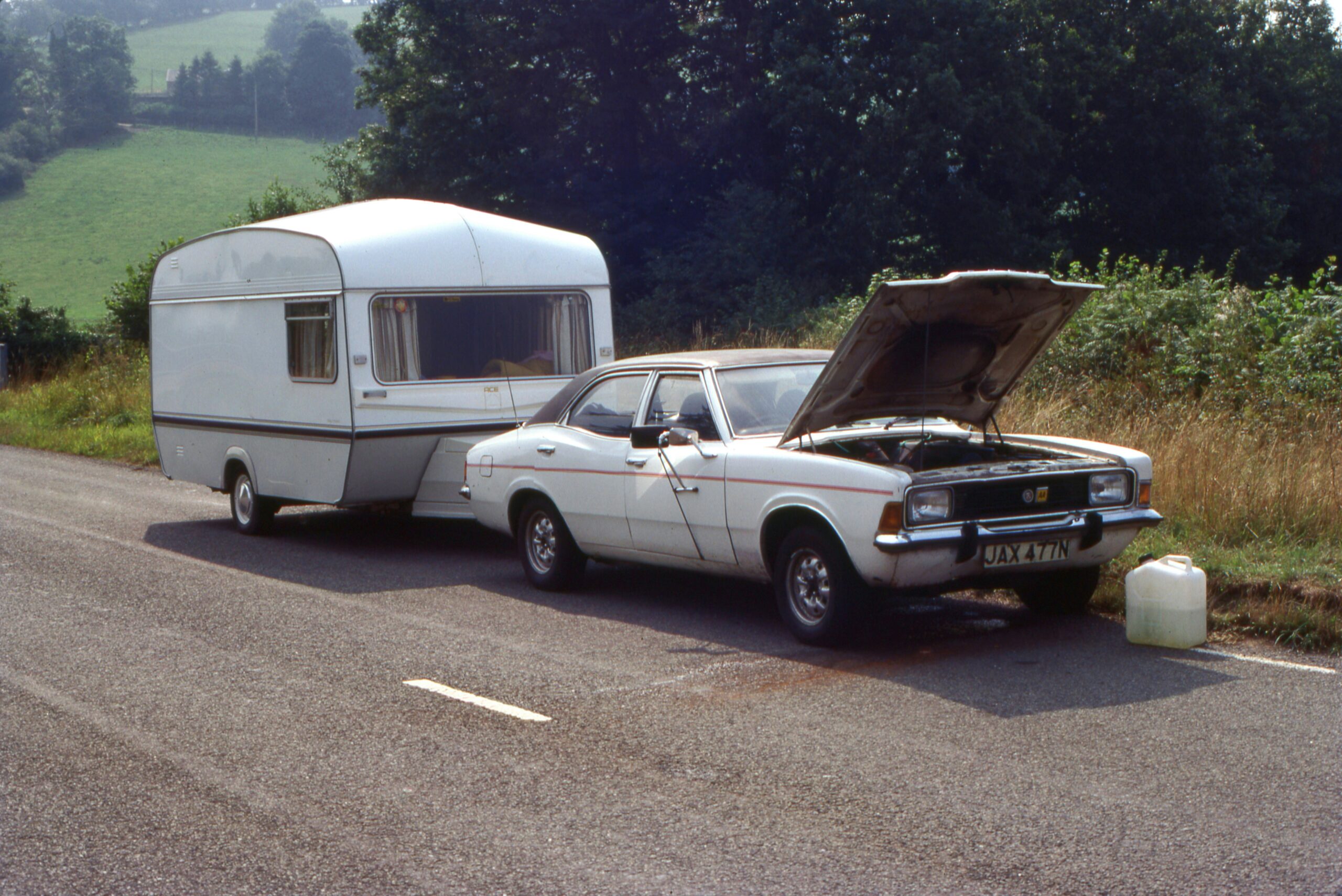 a car with a camper on the back of it parked next to a truck